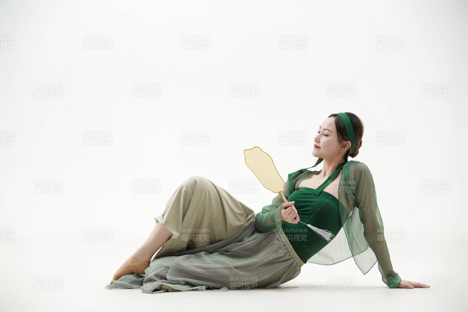 身穿青色古典舞蹈服装手拿蒲扇跳舞的少女图片