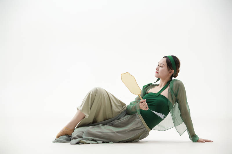 身穿青色古典舞蹈服装手拿蒲扇跳舞的少女图片