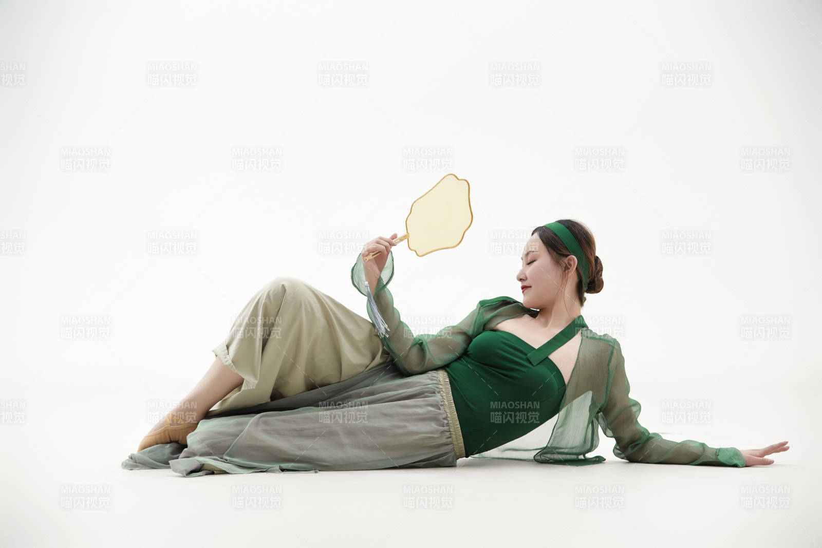 身穿青色古典舞蹈服装手拿蒲扇跳舞的少女图片