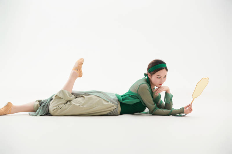 身穿青色古典舞蹈服装手拿蒲扇跳舞的少女图片