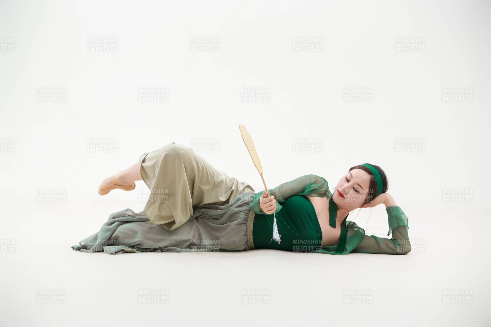 身穿青色古典舞蹈服装手拿蒲扇跳舞的少女图片