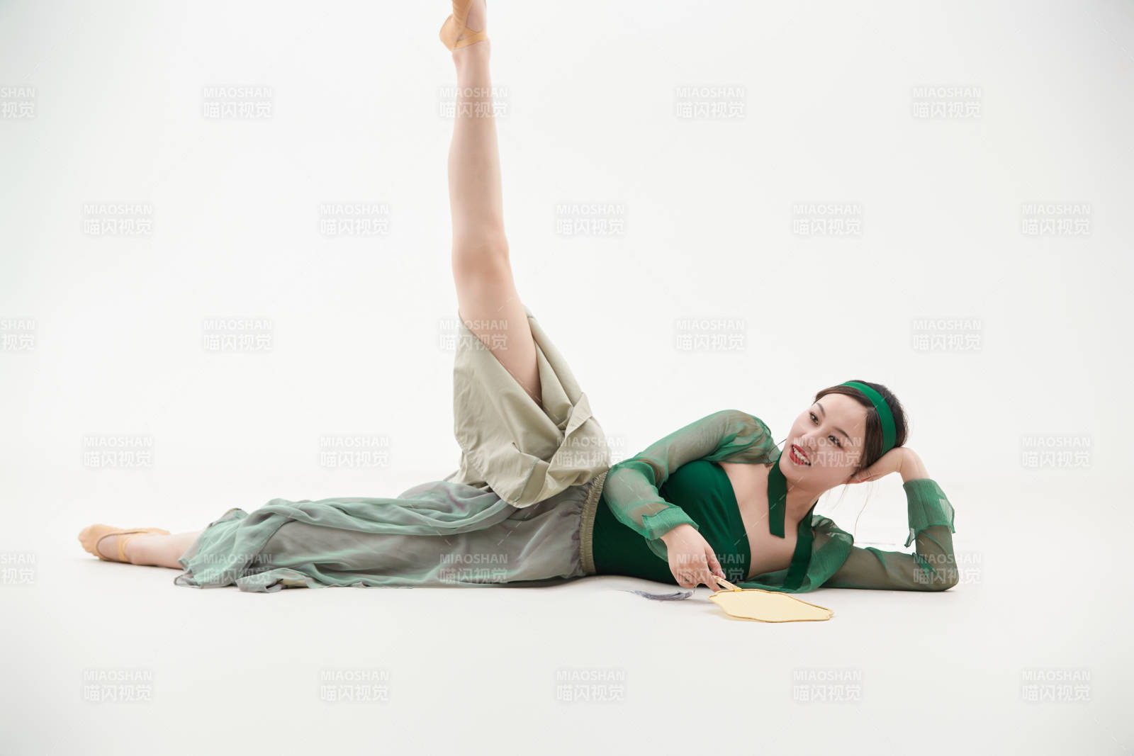 身穿青色古典舞蹈服装手拿蒲扇跳舞的少女图片