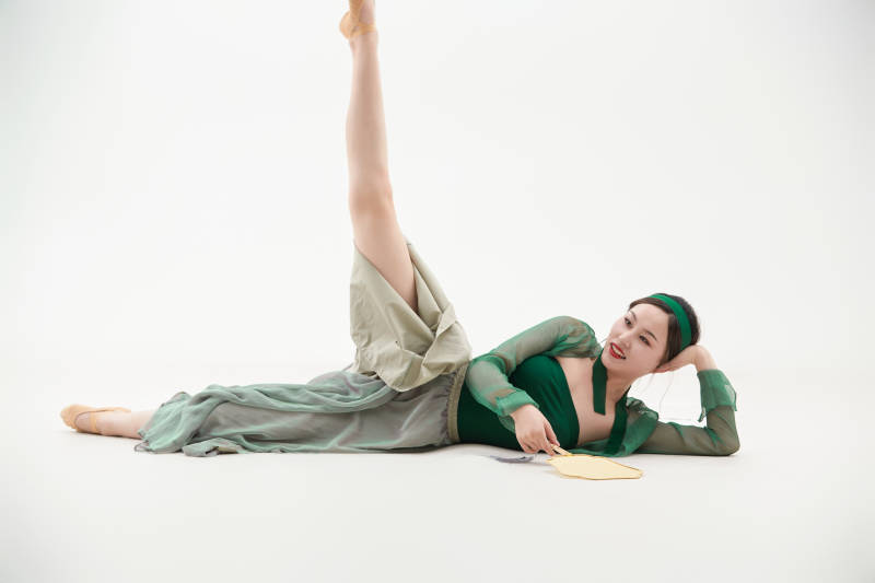 身穿青色古典舞蹈服装手拿蒲扇跳舞的少女图片