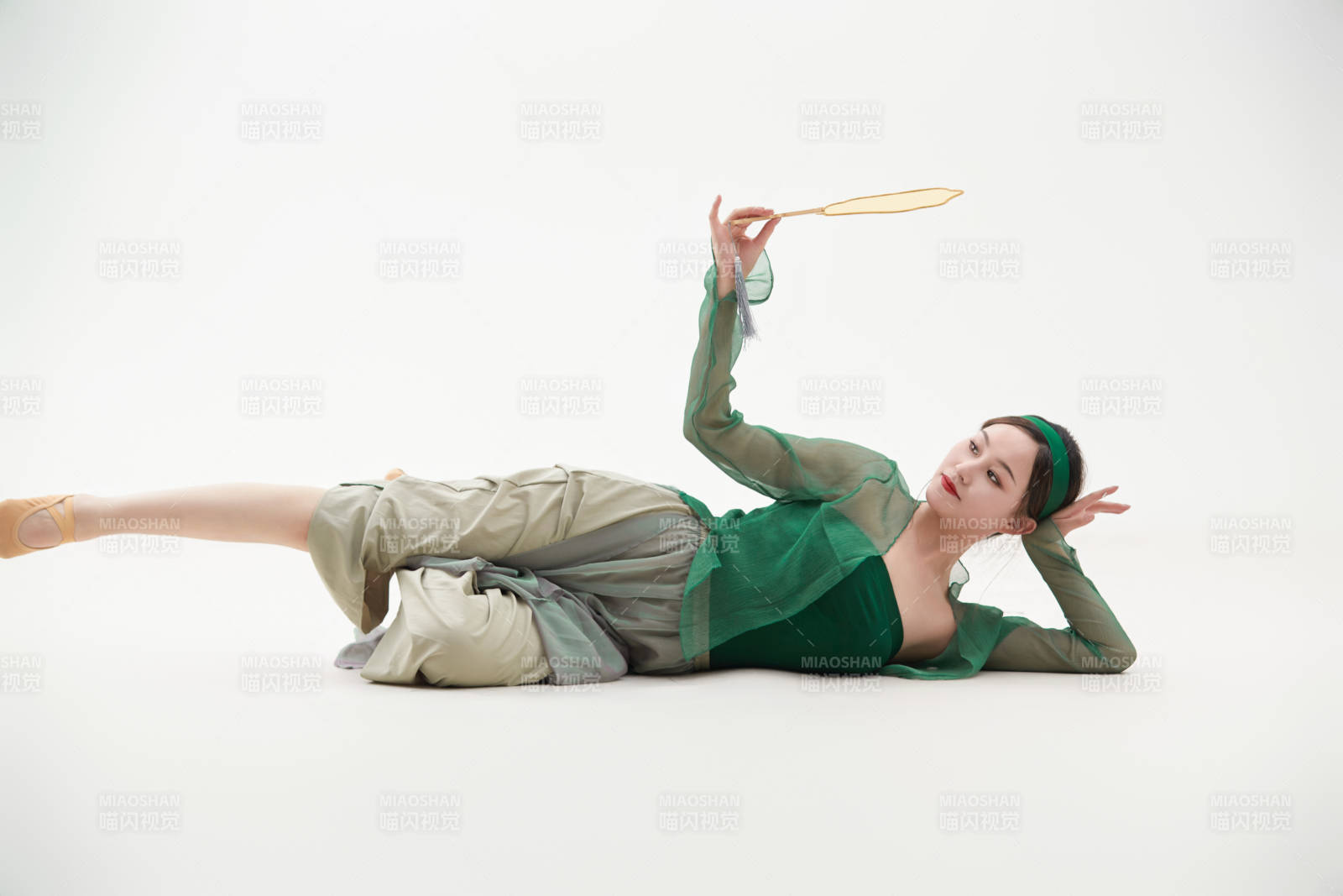 身穿青色古典舞蹈服装手拿蒲扇跳舞的少女图片