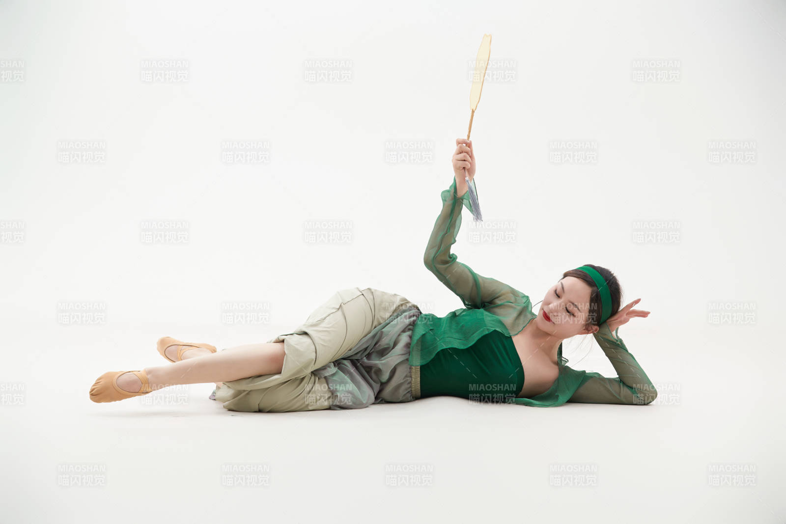 身穿青色古典舞蹈服装手拿蒲扇跳舞的少女图片