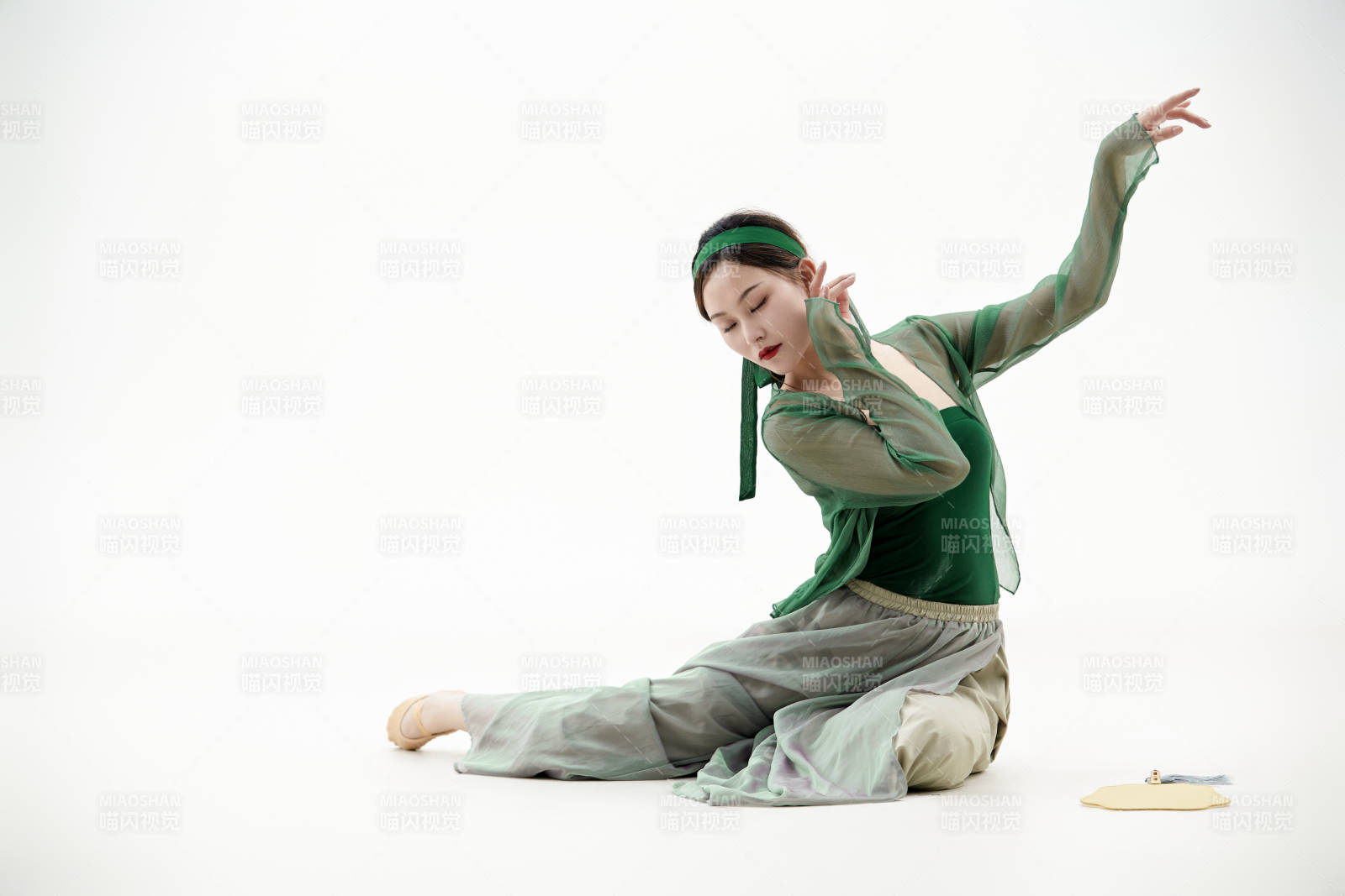 身穿青色古典舞蹈服装手拿蒲扇跳舞的少女图片