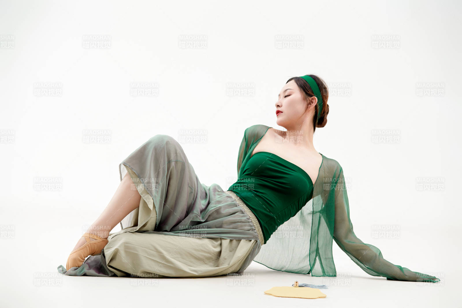 身穿青色古典舞蹈服装手拿蒲扇跳舞的少女图片