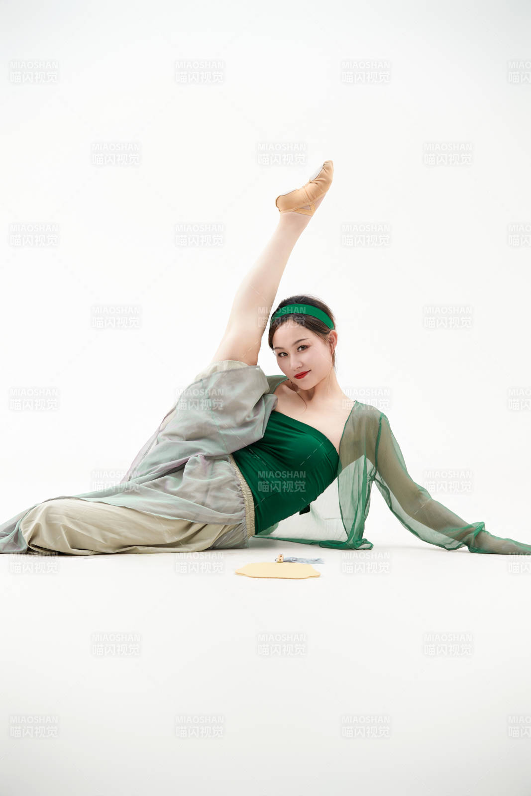 身穿青色古典舞蹈服装手拿蒲扇跳舞的少女图片