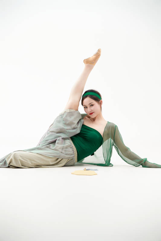 身穿青色古典舞蹈服装手拿蒲扇跳舞的少女图片