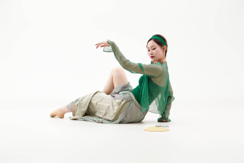 身穿青色古典舞蹈服装手拿蒲扇跳舞的少女图片