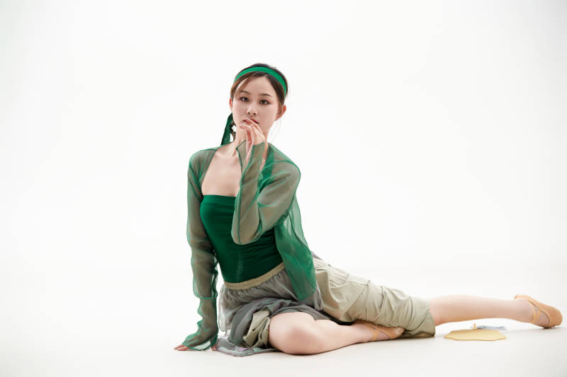 身穿青色古典舞蹈服装手拿蒲扇跳舞的少女图片