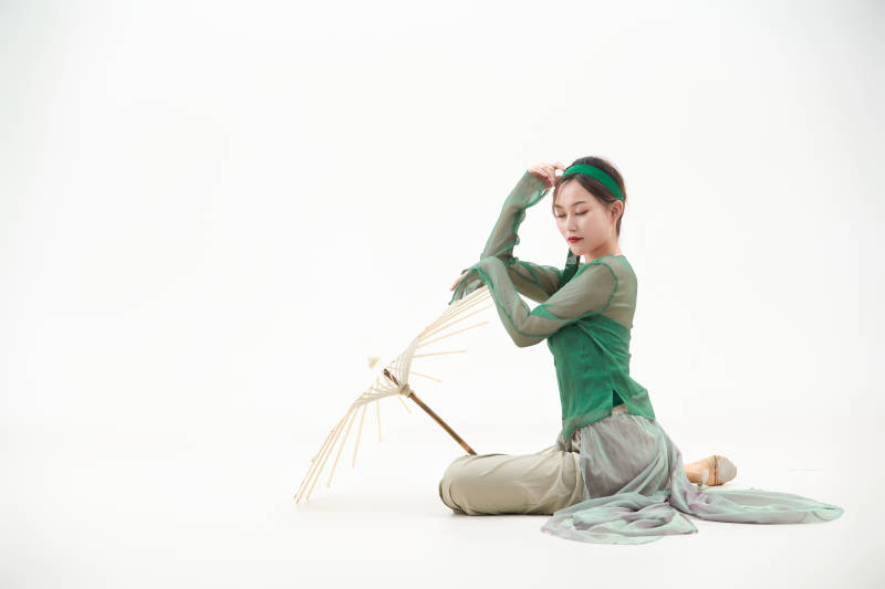 身穿青色古典舞蹈服装手拿蒲扇跳舞的少女图片