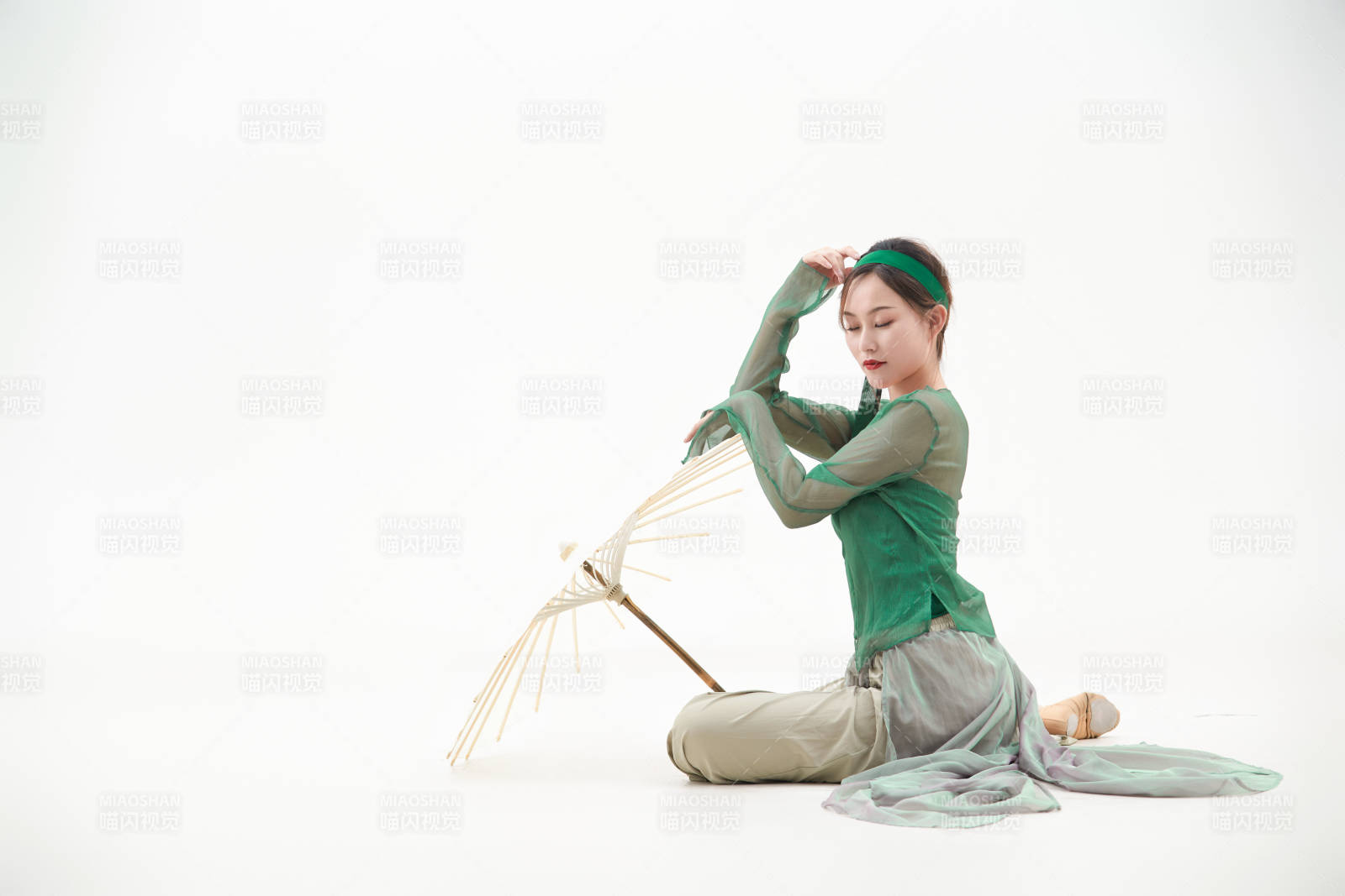 身穿青色古典舞蹈服装手拿蒲扇跳舞的少女图片