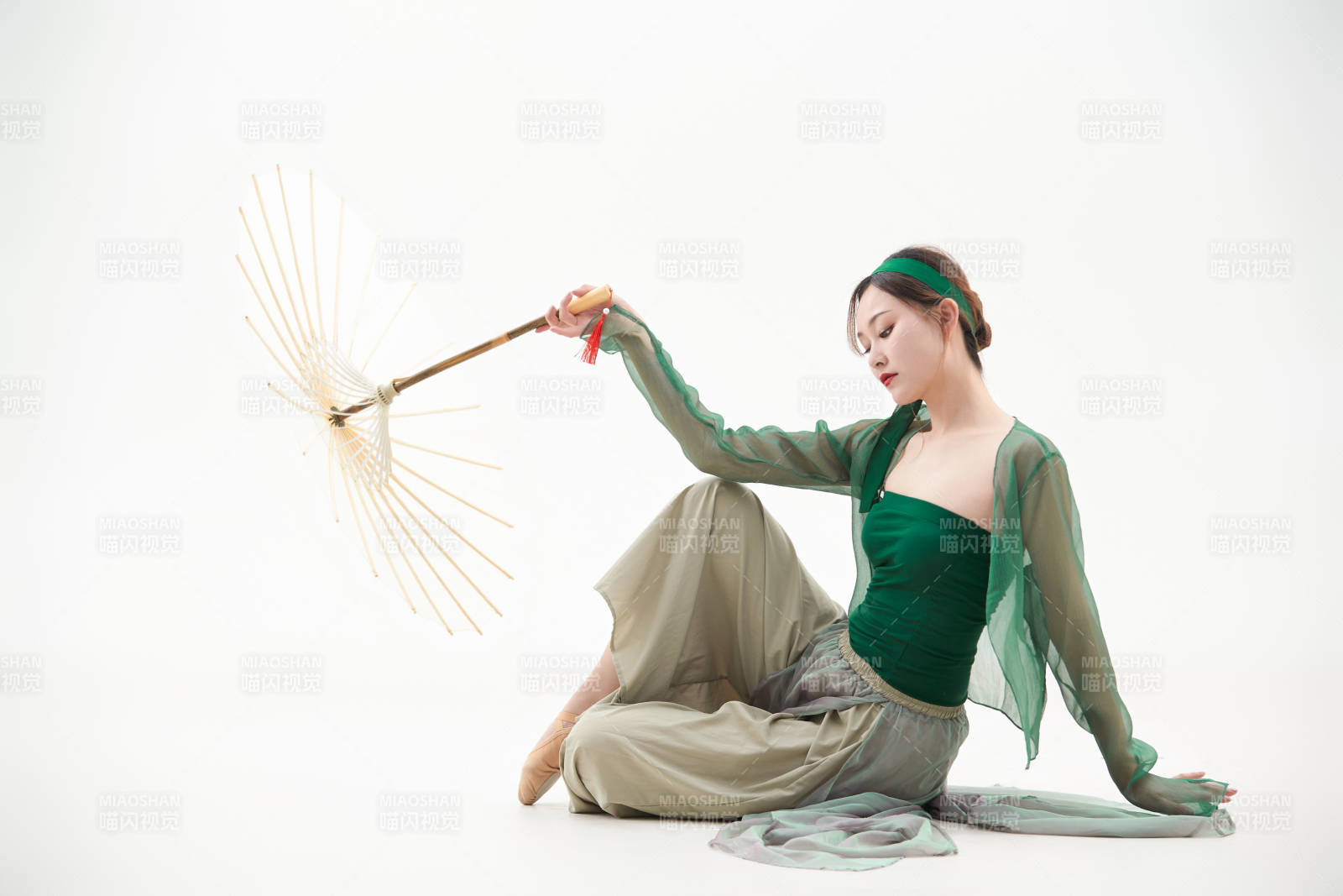 身穿青色古典舞蹈服装手拿蒲扇跳舞的少女图片