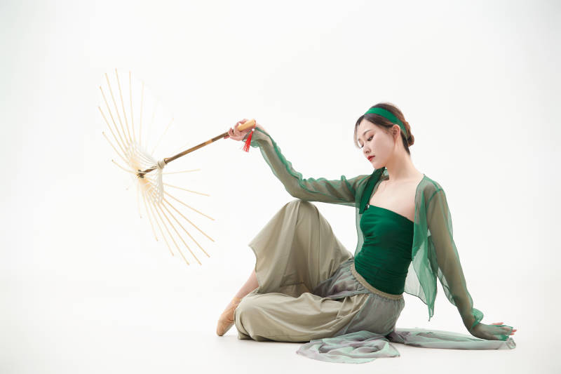 身穿青色古典舞蹈服装手拿蒲扇跳舞的少女图片