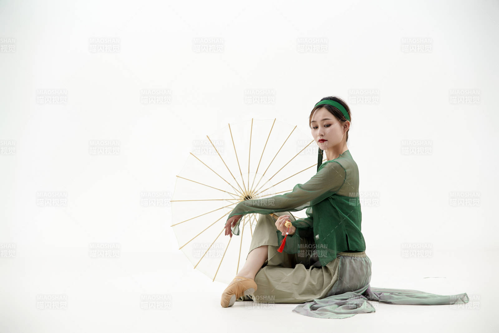 身穿青色古典舞蹈服装手拿蒲扇跳舞的少女图片