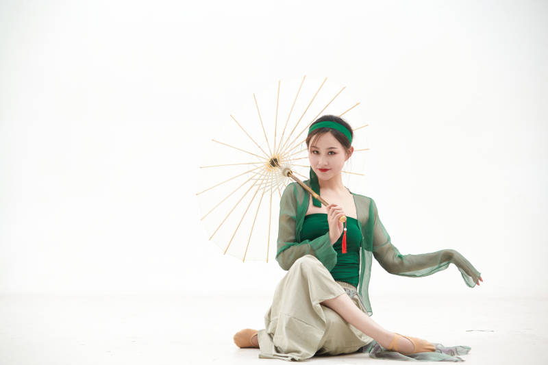 身穿青色古典舞蹈服装手拿蒲扇跳舞的少女图片