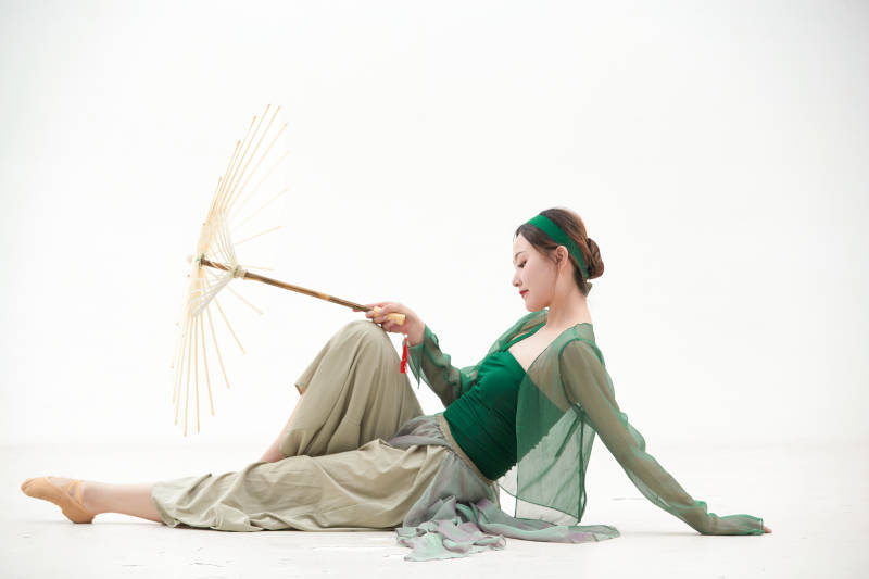 身穿青色古典舞蹈服装手拿蒲扇跳舞的少女图片