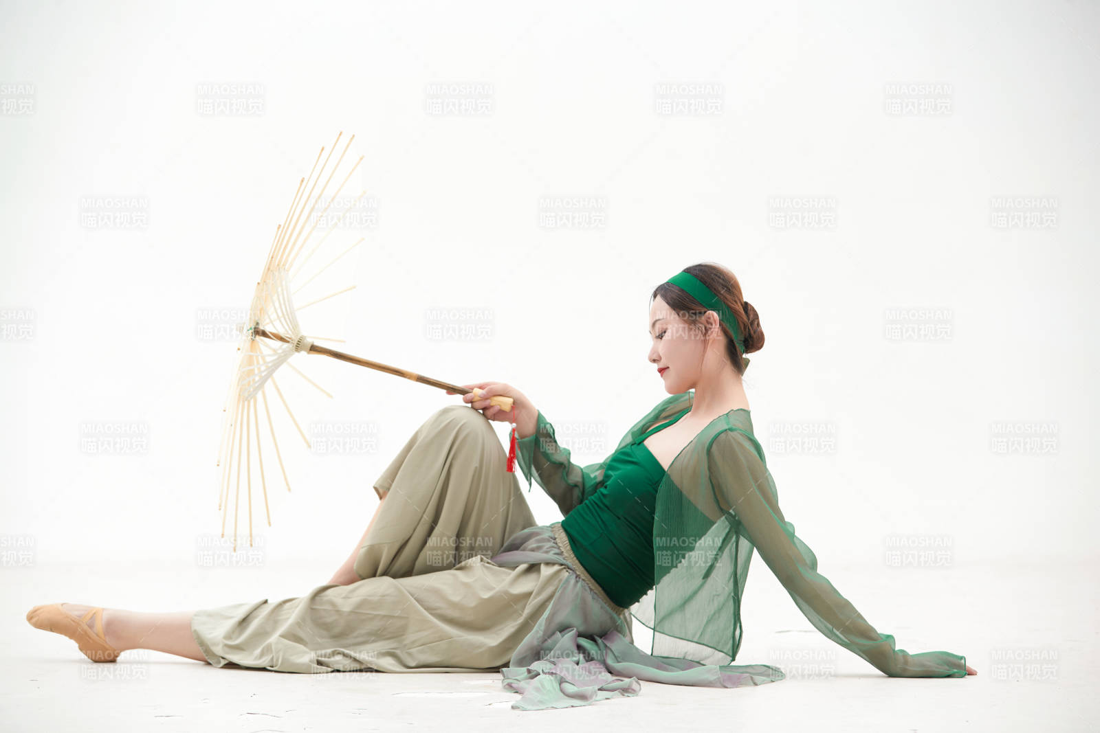 身穿青色古典舞蹈服装手拿蒲扇跳舞的少女图片