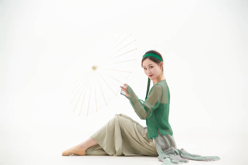 身穿青色古典舞蹈服装手拿蒲扇跳舞的少女图片