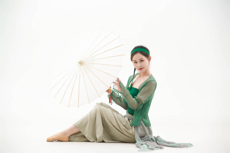 身穿青色古典舞蹈服装手拿蒲扇跳舞的少女图片