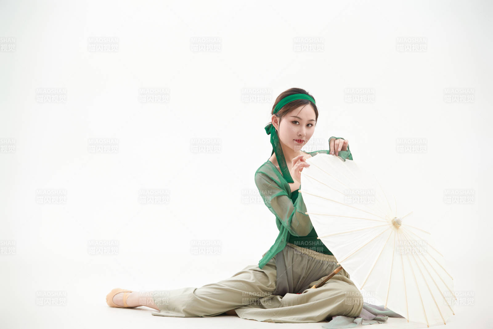 身穿青色古典舞蹈服装手拿蒲扇跳舞的少女图片