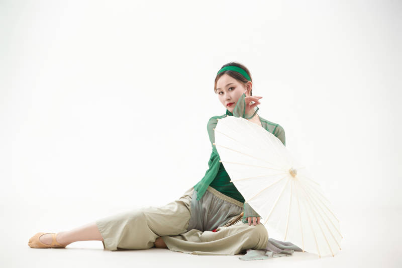 身穿青色古典舞蹈服装手拿蒲扇跳舞的少女图片