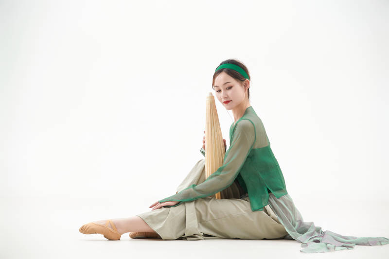 身穿青色古典舞蹈服装手拿蒲扇跳舞的少女图片