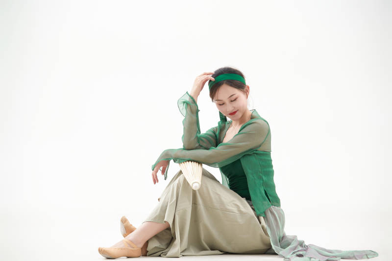 身穿青色古典舞蹈服装手拿蒲扇跳舞的少女图片