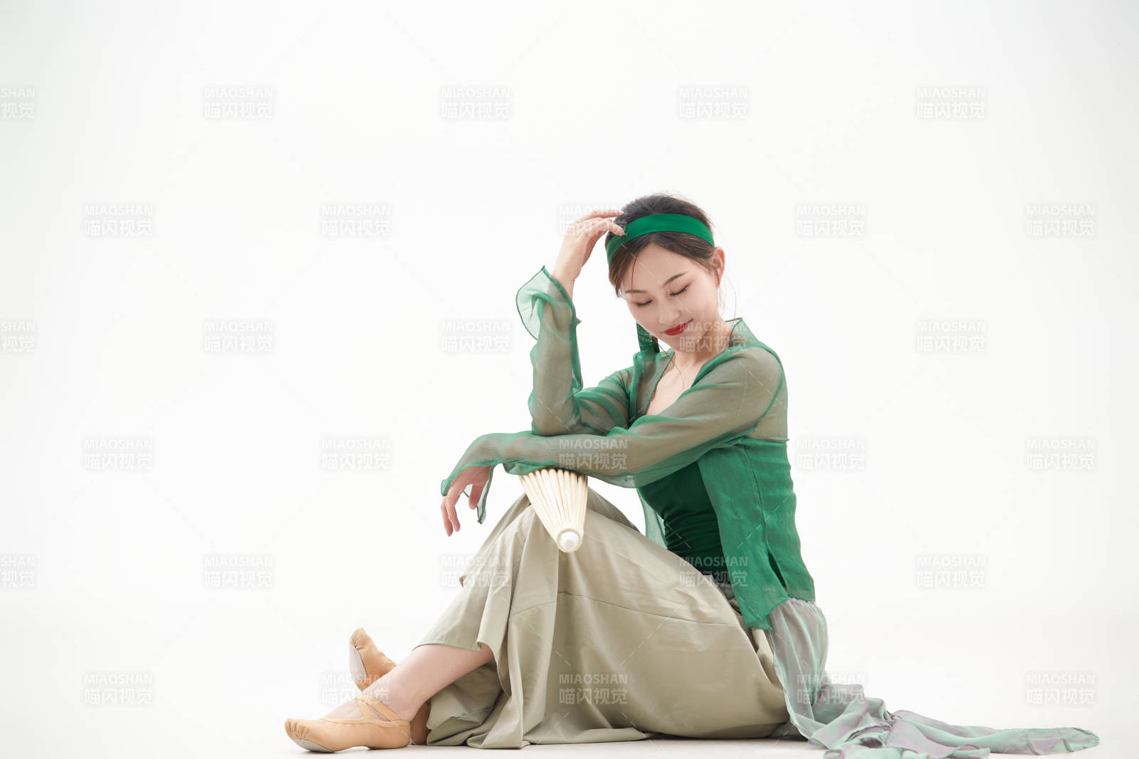 身穿青色古典舞蹈服装手拿蒲扇跳舞的少女图片