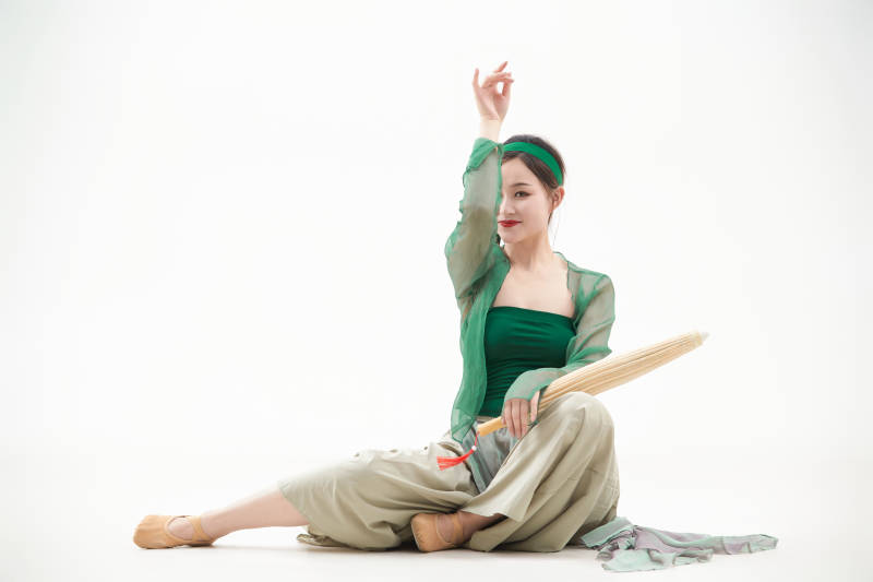 身穿青色古典舞蹈服装手拿蒲扇跳舞的少女图片