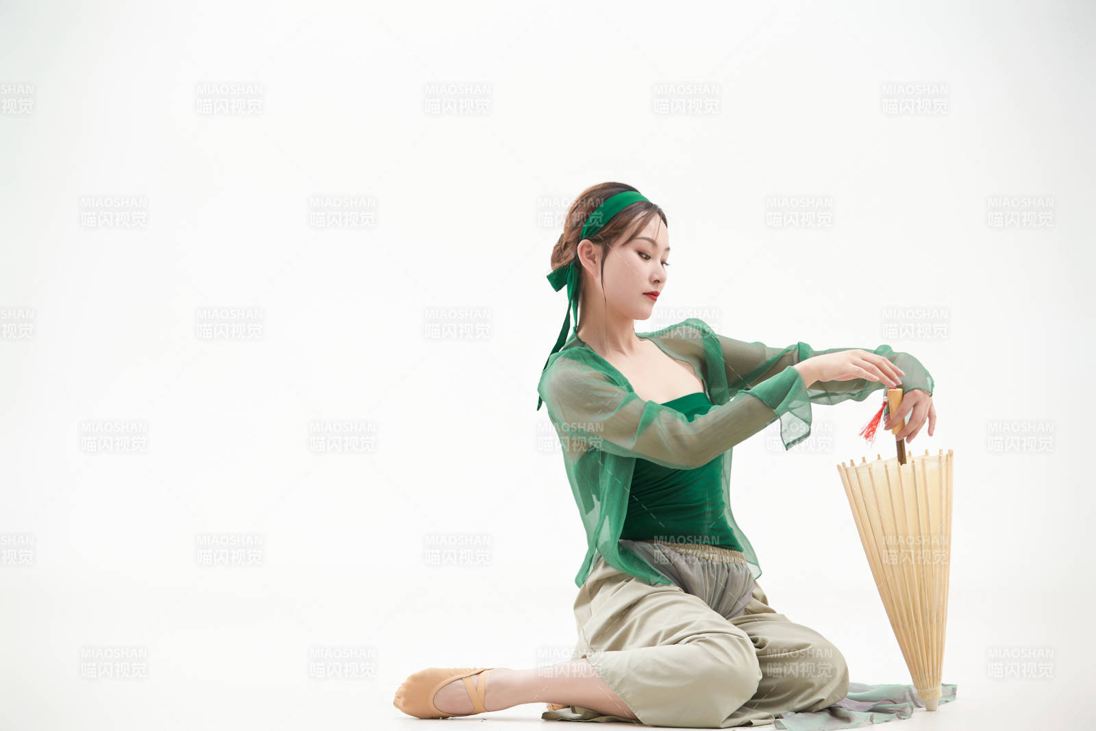 身穿青色古典舞蹈服装手拿蒲扇跳舞的少女图片