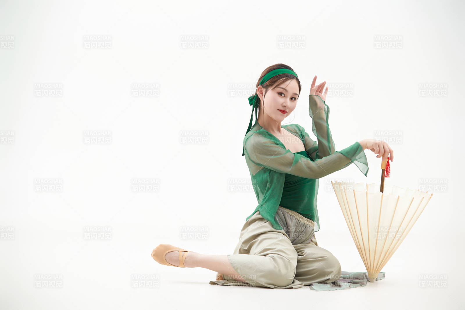 身穿青色古典舞蹈服装手拿蒲扇跳舞的少女图片