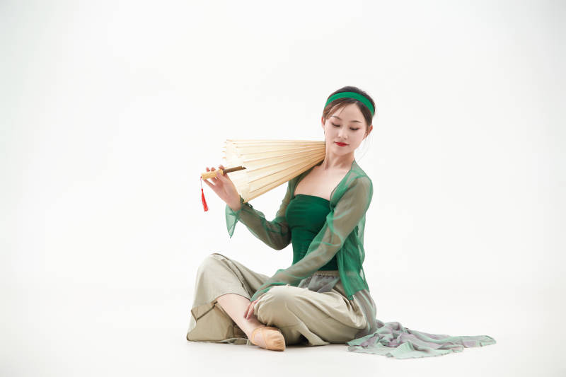 身穿青色古典舞蹈服装手拿蒲扇跳舞的少女图片