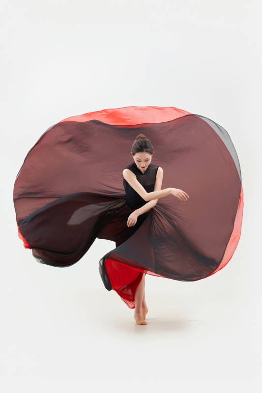 身穿红黑相间的舞蹈长裙翩翩起舞的少女图片