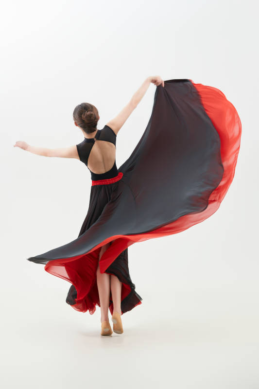 身穿红黑相间的舞蹈长裙翩翩起舞的少女图片