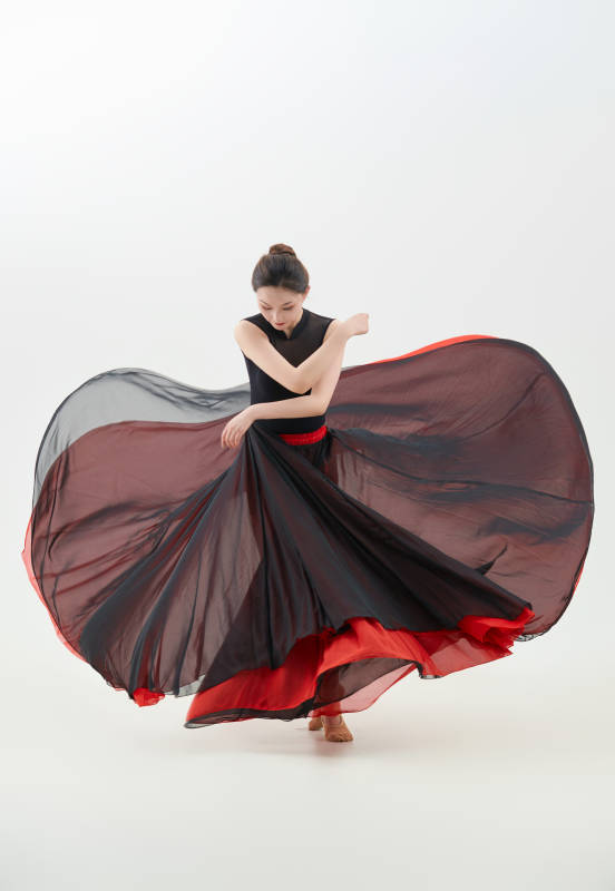 身穿红黑相间的舞蹈长裙翩翩起舞的少女图片