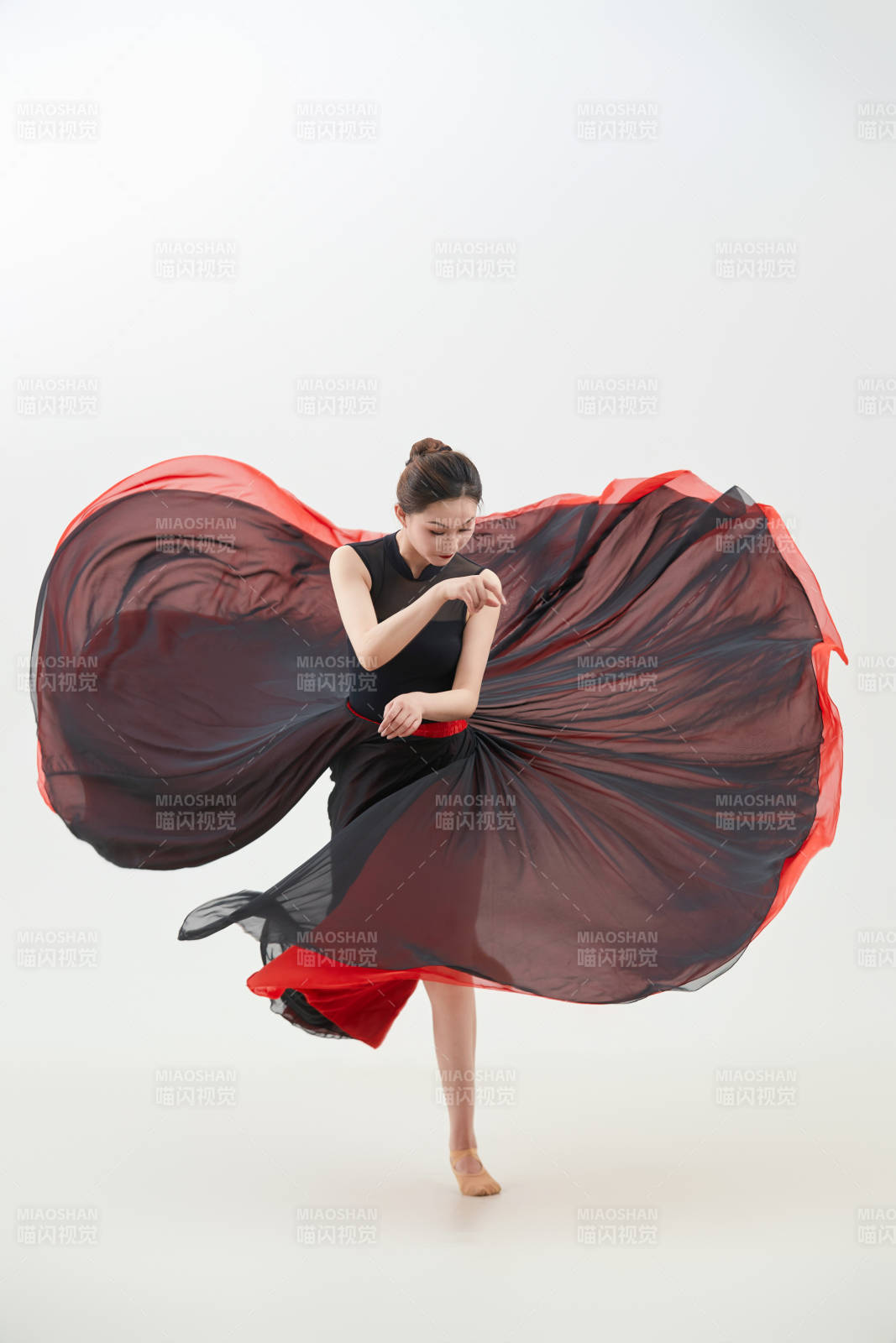 身穿红黑相间的舞蹈长裙翩翩起舞的少女图片