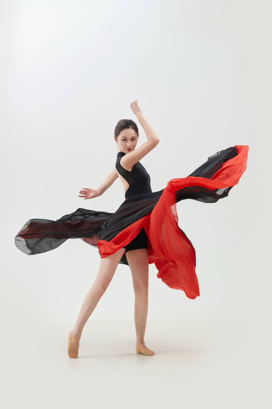 身穿红黑相间的舞蹈长裙翩翩起舞的少女图片