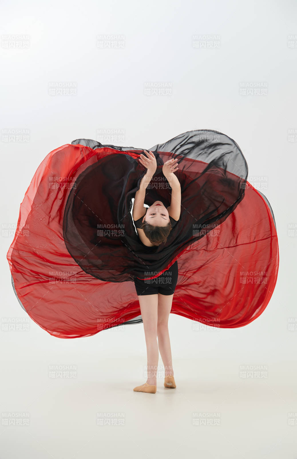 身穿红黑相间的舞蹈长裙翩翩起舞的少女图片