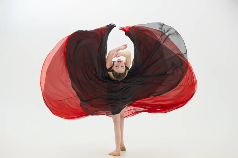 身穿红黑相间的舞蹈长裙翩翩起舞的少女图片