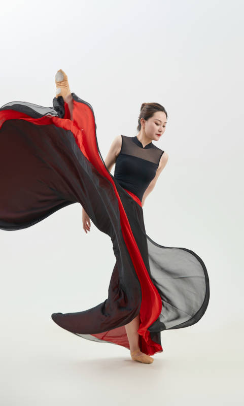 身穿红黑相间的舞蹈长裙翩翩起舞的少女图片