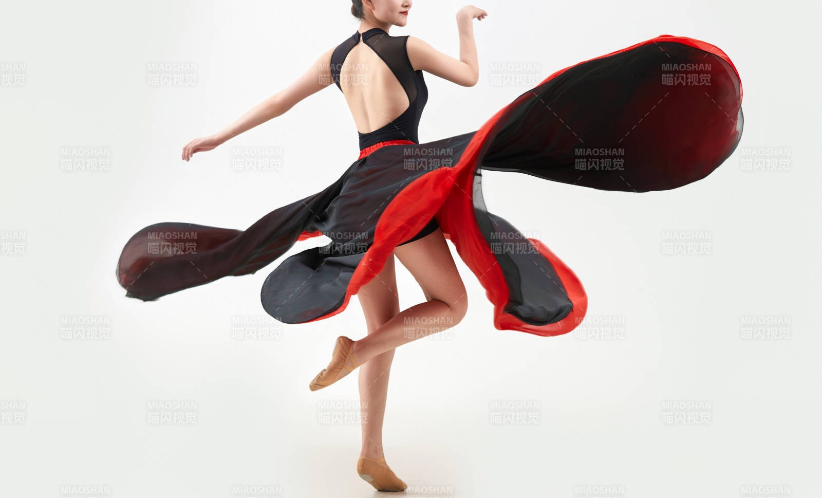 身穿红黑相间的舞蹈长裙翩翩起舞的少女图片
