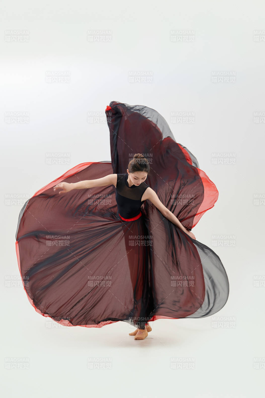 身穿红黑相间的舞蹈长裙翩翩起舞的少女图片