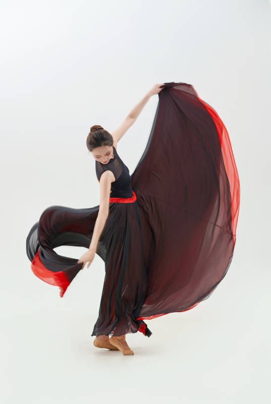 身穿红黑相间的舞蹈长裙翩翩起舞的少女图片