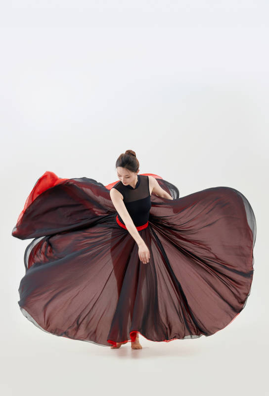 身穿红黑相间的舞蹈长裙翩翩起舞的少女图片