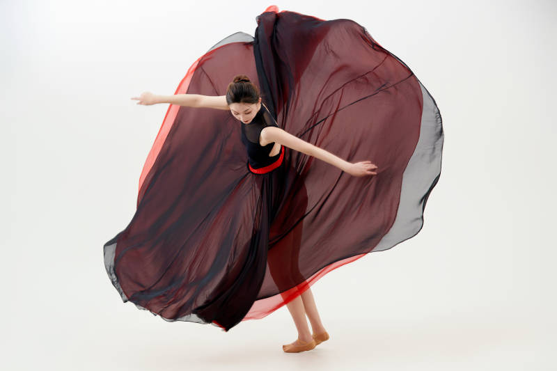 身穿红黑相间的舞蹈长裙翩翩起舞的少女图片