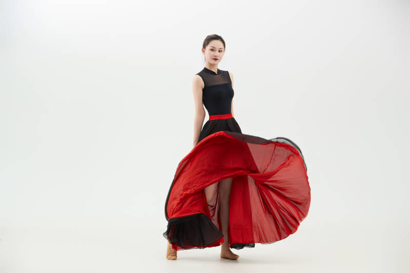 身穿红黑相间的舞蹈长裙翩翩起舞的少女图片
