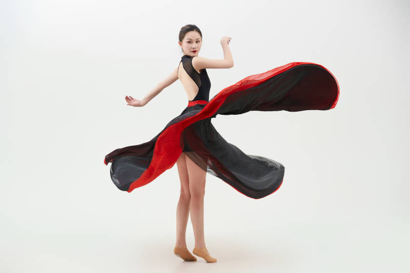 身穿红黑相间的舞蹈长裙翩翩起舞的少女图片