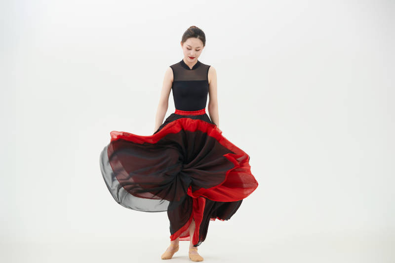 身穿红黑相间的舞蹈长裙翩翩起舞的少女图片